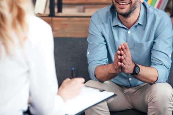 psychologist taking notes during a therapy sessions with patient.