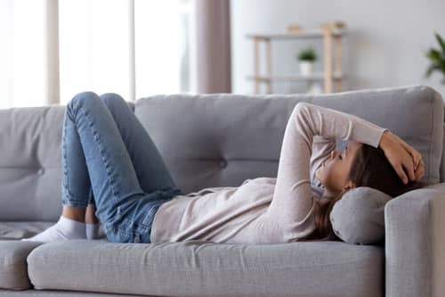 woman upset laying on couch