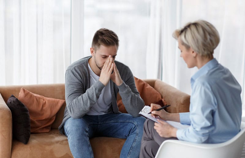 man in therapy with psychologist.