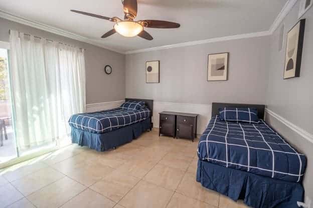 AMFM facility shared bedroom with two twin beds featuring navy plaid bedding