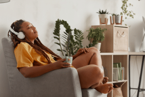 woman with headphones on, looking relaxed in a chair, experiencing the opposite of anxiety