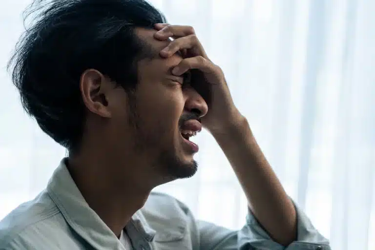 man with hand on head, agonizing over high-functioning schizophrenia