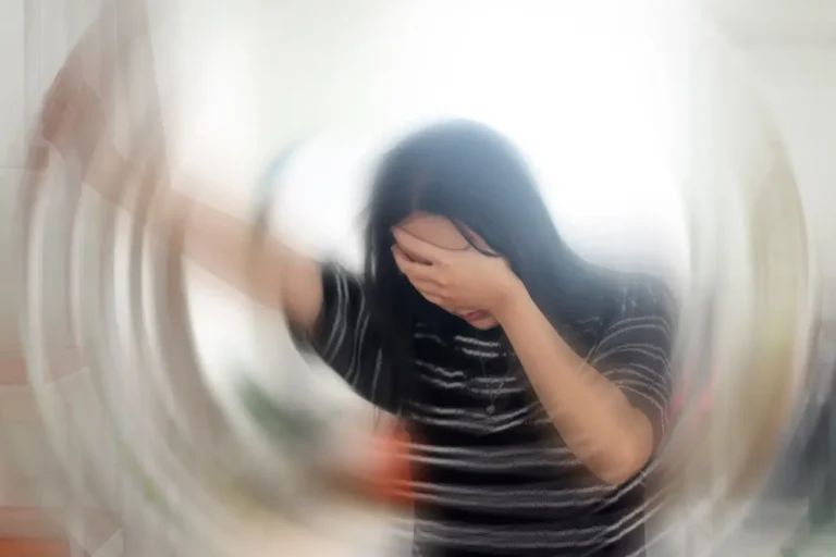 Woman with head in hands and mind spinning, wondering, "what are common symptoms of anxiety disorder?"