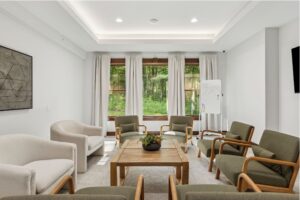 Bright room with large windows and group therapy chairs around a center table