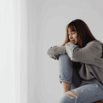Woman sitting on a chair crying due to anxiety, in need of anxiety treatment