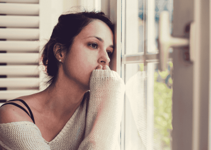 woman looking sad looking out the window in need of mood disorder treatment