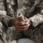 African american veteran with his hands clenched together, in need of PTSD treatment