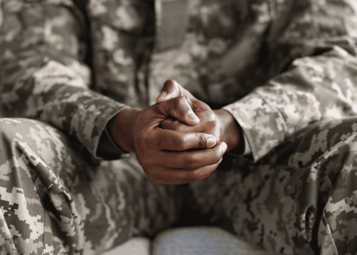 African american veteran with his hands clenched together, in need of PTSD treatment