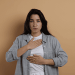 Woman with her hand on her chest focusing on how to stop a panic attack quickly