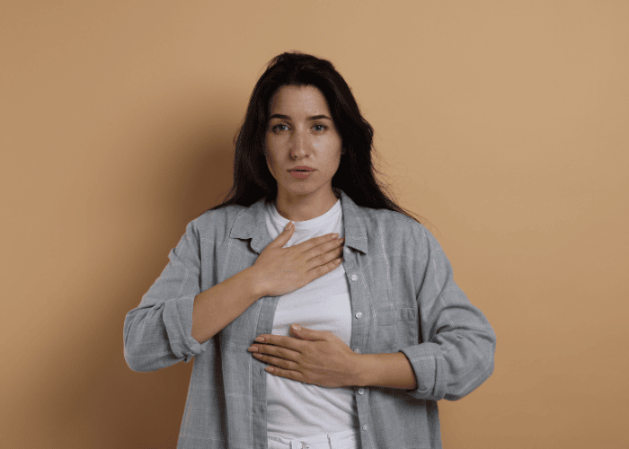 Woman with her hand on her chest focusing on how to stop a panic attack quickly