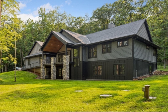 One of AMFM facilities featuring a covered porch with stone columns, situated on a green lawn.