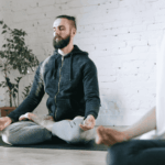 Man doing a yoga class as one of his anxiety disorder self-care strategies