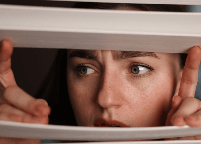 Woman looking out of the window looking worried due to paranoid personality disorder in adults