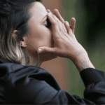 Woman standing up with her hands in her head struggling due to borderline personality disorder in adults