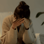 Woman sitting with her head in her hands due to cyclothymic disorder in adults