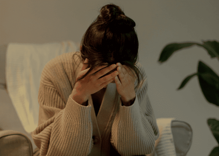Woman sitting with her head in her hands due to cyclothymic disorder in adults