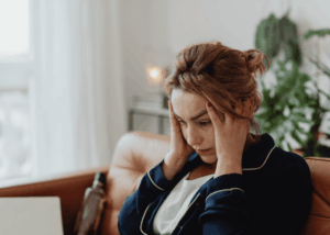 Woman in her pajamas with her head in hear hands struggling with generalized anxiety disorder in adults