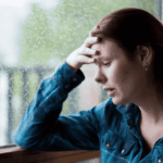 Woman with hand on her head overwhelmed due to Schizotypal Personality Disorder in Adults