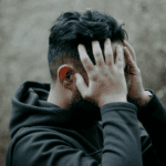 Man with his hands on head struggling with Schizoid Personality Disorder in Adults