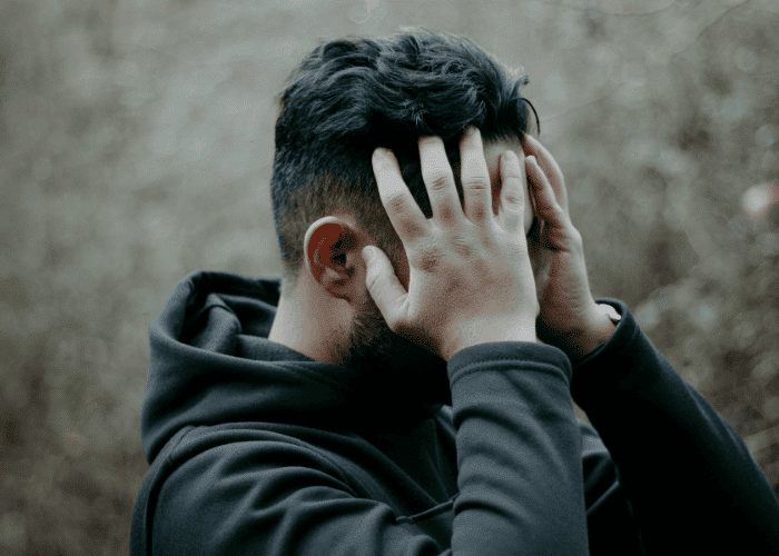 Man with his hands on head struggling with Schizoid Personality Disorder in Adults