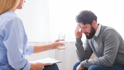 Person talking with therapist about mental health treatment payment options