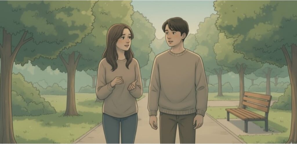 A couple walking together in the park, having a conversation on a tree-lined path.