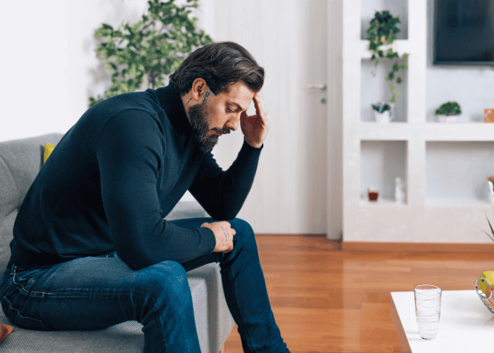 Man with his head in his hands, in need of Disinhibited Social Engagement Disorder (DSED) Treatment