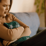 Woman looking frustrating clutching a pillow, in need of intensive thoughts treatment for OCD & anxiety