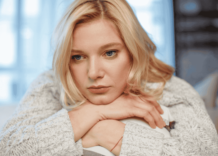 Woman with her head on her hands struggling with one of the common types of mood disorders