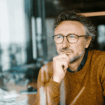 Man looking out the window into the distance in need of depersonalization and derealization disorder treatment