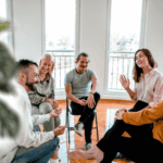 Group of people sitting and chatting happily during an acceptance and commitment therapy session