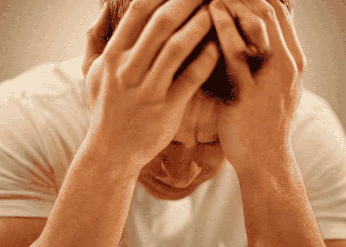 Man with his head in his hands in distress struggling before changes to Minnesota behavioral health laws