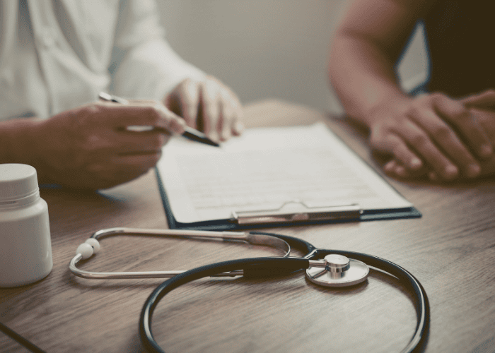 Man sitting with a doctor in a healthcare setting experiencing mental health stigma