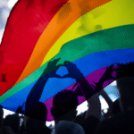 Crowd with rainbow flag, representing California LGBTQ+ crisis hotlines