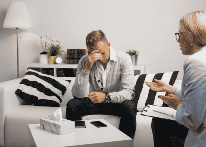 Man in therapy session struggling, representing Washington's mental health parity rules