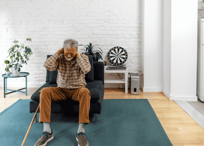 Woman sitting on an armchair with his hands on his neck managing chronic pain