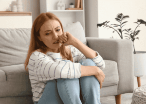 Woman sitting on the floor biting her nails due to political stress and anxiety