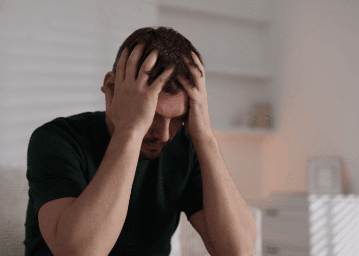 Man with his hands on his head looking stressed and worried about using mental health apps