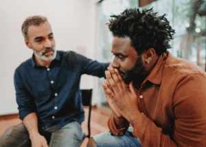 One man offering physical support to another while wondering when to seek professional help