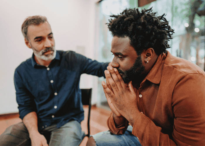 One man offering physical support to another while wondering when to seek professional help