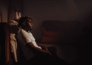 Man sitting in the dark struggling with mental health crisis warning signs