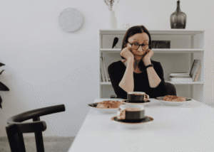 Woman sitting at the breakfast table managing loss of appetite as a mental health crisis warning sign