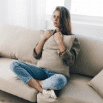 Woman clutching a pillow struggling with co-occurring disorders
