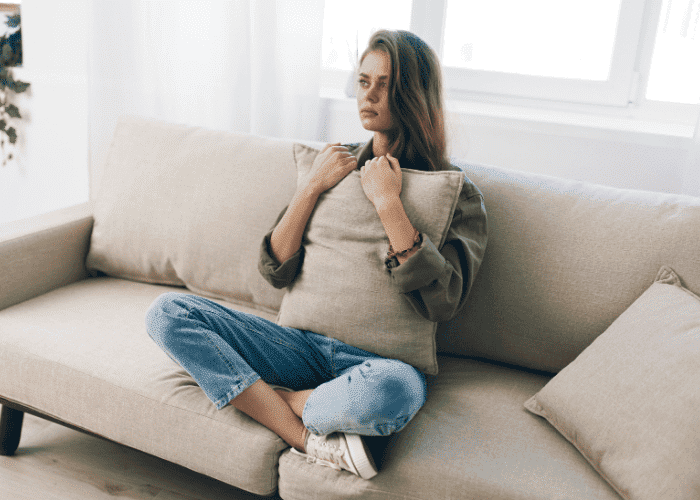 Woman clutching a pillow struggling with co-occurring disorders