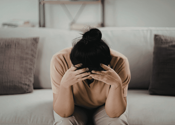 Woman with head in hands managing underrecognized signs of adhd in women