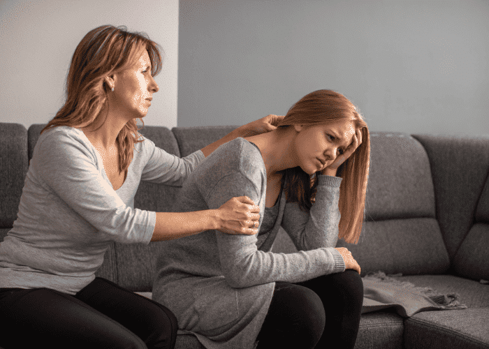 Mother comforting daughter who is managing intergenerational depression