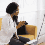 Woman sitting on the couch using her laptop during virtual therapy