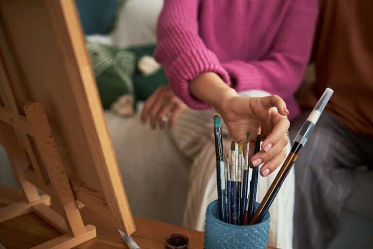 Woman picking a paint brush during art therapy
