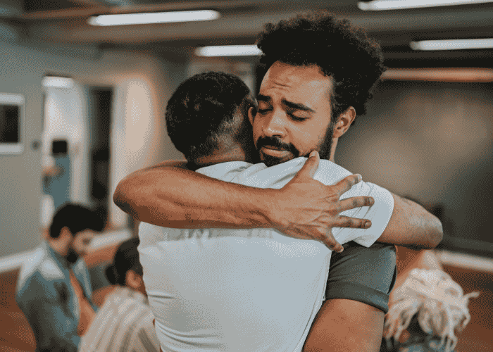 Two men hugging after turning mental health awareness into meaningful actions