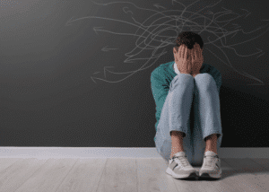 Man sitting with his knees to his chest due to lack of mental health awareness